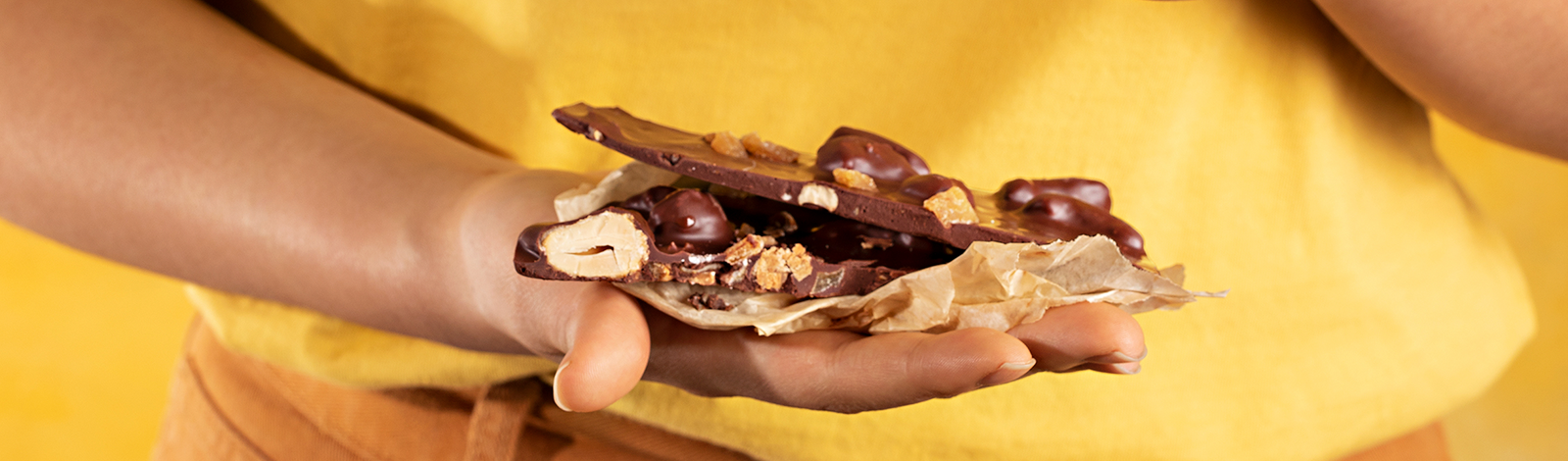 Mão segurando pedaços do chocolate quebra-quebra